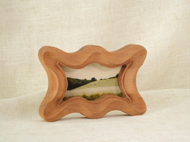 Handcrafted wooden picture frame, with a wavy, irregularly carved dog bone frame, suitable for wall or table decoration.